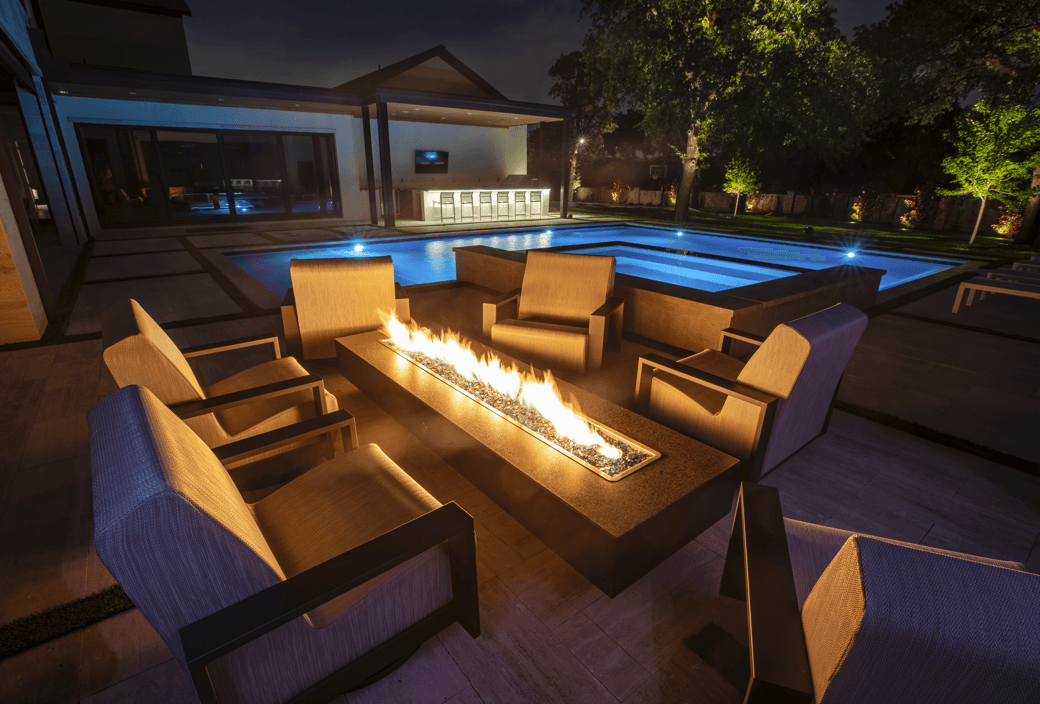 Fire feature illuminating a luxury outdoor living area at dusk