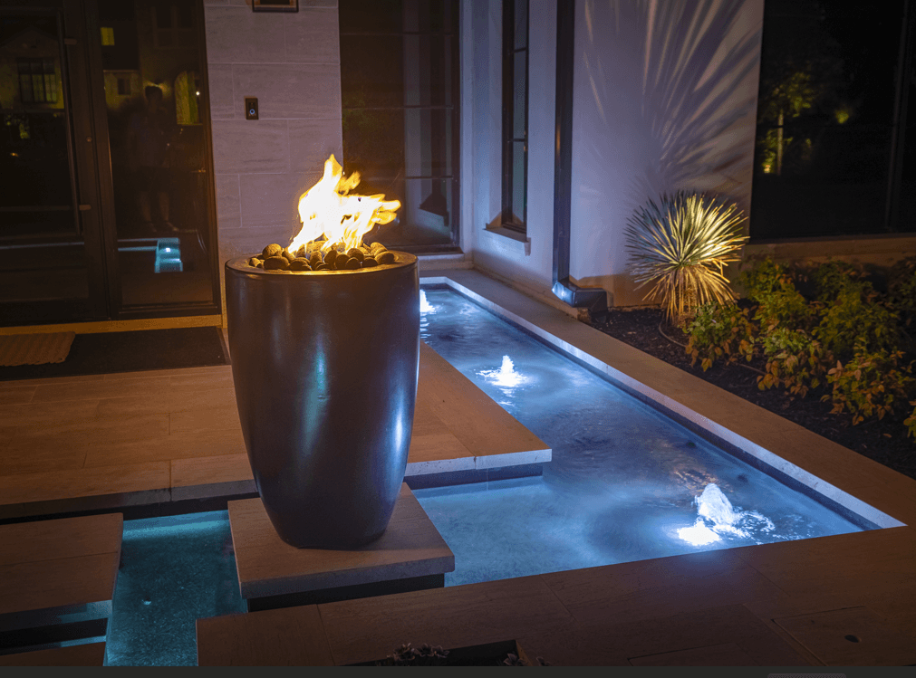 Fire feature illuminating a luxury outdoor living area at dusk