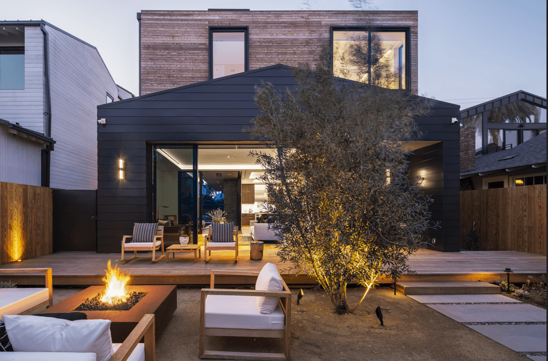 Fire feature illuminating a luxury outdoor living area at dusk