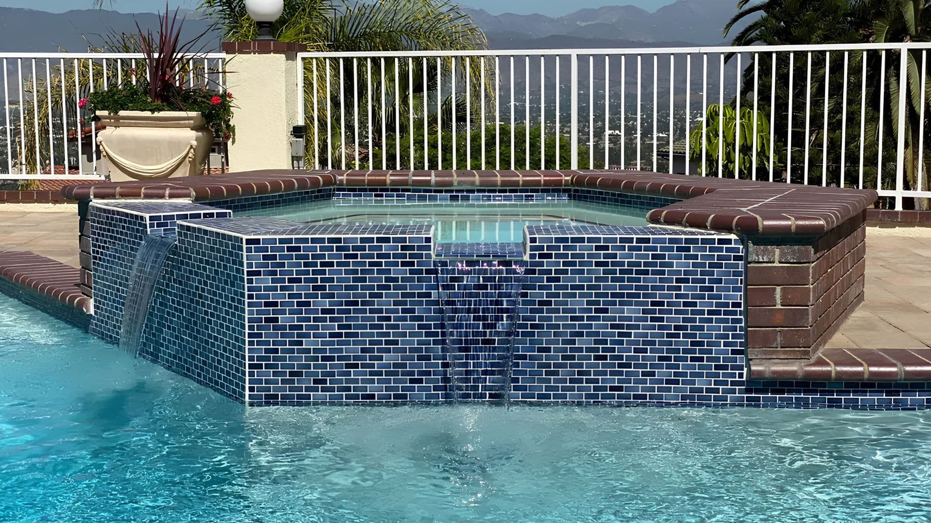 Sunset view of completed pool project with palm trees and lighting
